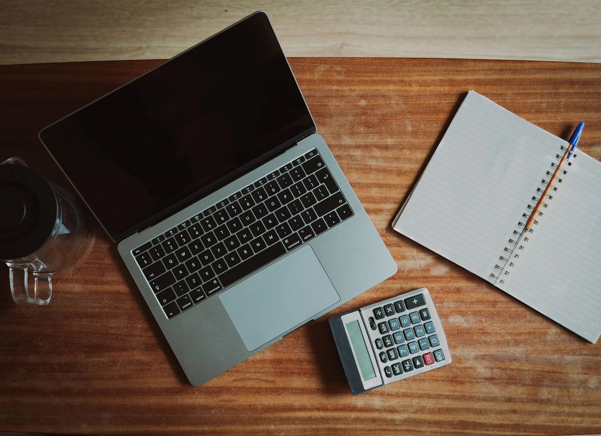 Workspace with laptop, notebook and calculator, cash-flow steering